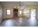 Bright living room with hardwood floors, brick fireplace, and vaulted ceilings with a ceiling fan at 11418 Geist Valley Dr, Indianapolis, IN 46236