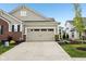 A well-lit two-car garage with a spacious driveway and neat landscaping at 11429 Lottie Cir, Noblesville, IN 46060