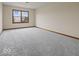 Spacious bedroom with soft gray carpet and natural light streaming through a window at 1205 Cypress Dr, Shelbyville, IN 46176