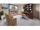 A staged carpeted bedroom has a desk, chairs, and balcony at 1205 Cypress Dr, Shelbyville, IN 46176