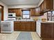 A kitchen is equipped with white appliances and wood cabinets at 1205 Cypress Dr, Shelbyville, IN 46176
