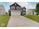Two-car garage featuring a long driveway and adjacent landscaping at 1255 Crabapple Rd, Franklin, IN 46131