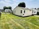 Simple backyard with a well-kept lawn, view of the home, and adjacent houses at 128 E 36Th St, Anderson, IN 46013