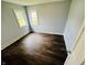 A bright bedroom with dark wood flooring and two windows allowing ample natural light at 128 E 36Th St, Anderson, IN 46013