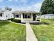 Charming single-story home featuring a well-maintained lawn and inviting entryway at 128 E 36Th St, Anderson, IN 46013