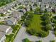Residential neighborhood showcases well-maintained homes surrounding a green space with mature trees at 12976 Walbeck Dr, Fishers, IN 46037