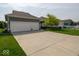 Long driveway leading to a two car garage, with lawn and a tree to the side at 12976 Walbeck Dr, Fishers, IN 46037