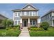 Charming two-story home with a beautifully landscaped front yard and inviting covered porch with stone accents at 12976 Walbeck Dr, Fishers, IN 46037