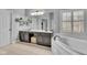 Bright bathroom with double sink vanity, soaking tub under window with shutters, and gray cabinets at 13304 Landwood Dr, Fishers, IN 46037