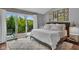 Bright bedroom features sliding glass doors to deck, gray walls, wood floors and personal photo gallery wall at 13304 Landwood Dr, Fishers, IN 46037