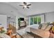 Comfortable bedroom offers a large window, ceiling fan, a dresser with TV, and sliding glass doors to a balcony at 13304 Landwood Dr, Fishers, IN 46037