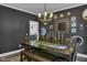Elegant dining room featuring dark walls, modern chandelier, and decorative mirrors at 13304 Landwood Dr, Fishers, IN 46037