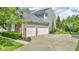 Exterior view showcasing a three-car garage, lush landscaping, and driveway at 13304 Landwood Dr, Fishers, IN 46037
