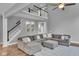 Cozy living room features a comfortable sectional sofa, staircase, and neutral decor, perfect for relaxation and gatherings at 13304 Landwood Dr, Fishers, IN 46037