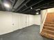 Finished basement area with dark-painted ceiling, neutral walls, and staircase leading to the upper floor at 1429 Udell St, Indianapolis, IN 46208