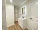 Well-lit bathroom features a modern vanity, an illuminated mirror, and light wood-look flooring at 1429 Udell St, Indianapolis, IN 46208