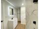 Contemporary bathroom features a modern vanity, an illuminated mirror, and a shower with tile surround at 1429 Udell St, Indianapolis, IN 46208