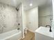 Modern bathroom features tiled shower, a white vanity with sleek fixtures, and wood-look flooring at 1429 Udell St, Indianapolis, IN 46208