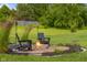 Backyard seating around a fire pit with decorative grasses and plantings at 1497 Maple Ridge Ct, Columbus, IN 47201