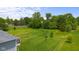 Expansive backyard featuring lush green grass, mature trees, and a sense of natural privacy at 1497 Maple Ridge Ct, Columbus, IN 47201