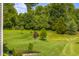 Picturesque backyard with lush green grass and mature trees, offering privacy and natural beauty at 1497 Maple Ridge Ct, Columbus, IN 47201