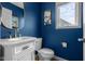 Modern bathroom features blue walls, gold fixtures, and a white vanity at 1497 Maple Ridge Ct, Columbus, IN 47201
