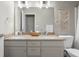Bathroom features a double vanity with granite countertop and a macrame wall hanging at 1497 Maple Ridge Ct, Columbus, IN 47201