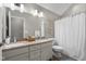 Bathroom featuring double sinks with granite countertop and a white shower curtain at 1497 Maple Ridge Ct, Columbus, IN 47201
