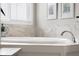 Bathtub area features modern window, relaxing decor, and tiled surround at 1497 Maple Ridge Ct, Columbus, IN 47201
