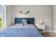 Comfortable bedroom features a blue headboard, white nightstand, and natural light at 1497 Maple Ridge Ct, Columbus, IN 47201