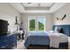 Bedroom with tray ceiling features a desk, dresser, and large windows overlooking the yard at 1497 Maple Ridge Ct, Columbus, IN 47201
