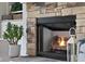 Stone fireplace with gas insert and lit logs provides a warm focal point in this living space at 1497 Maple Ridge Ct, Columbus, IN 47201