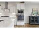 Bright kitchen features stainless steel appliances, white cabinetry, and a subway tile backsplash, complete with hardwood flooring at 1497 Maple Ridge Ct, Columbus, IN 47201
