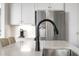 Close-up of a kitchen sink with a black faucet and stainless steel refrigerator in the background at 1497 Maple Ridge Ct, Columbus, IN 47201