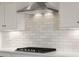 Modern kitchen features a stainless steel range hood and white subway tile backsplash at 1497 Maple Ridge Ct, Columbus, IN 47201