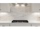 Tile backsplash above a gas stovetop enhances the modern kitchen with classic accents at 1497 Maple Ridge Ct, Columbus, IN 47201