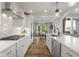 The kitchen area features modern white cabinetry, wood flooring, an island, and stainless appliances at 1497 Maple Ridge Ct, Columbus, IN 47201
