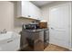 Bright laundry room featuring a stainless steel washer/dryer and a white utility sink at 1497 Maple Ridge Ct, Columbus, IN 47201