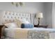 Comfortable main bedroom showcasing tufted headboard and warm lighting, enhanced by dark wood nightstands on both sides of the bed at 1497 Maple Ridge Ct, Columbus, IN 47201