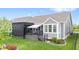 Backyard view of a home with a covered deck, screen shade, a white awning and beautifully landscaped grass at 1505 Avondale Dr, Westfield, IN 46074