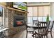 Cozy dining area featuring a brick fireplace and view of the TV in a sunroom at 1505 Avondale Dr, Westfield, IN 46074