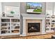 Cozy fireplace with white mantel, built-in bookshelves, and a television above the mantel at 1505 Avondale Dr, Westfield, IN 46074