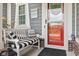A charming front porch features a white bench with cushions, a decorative owl, and a red door with glass pane at 1505 Avondale Dr, Westfield, IN 46074