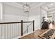 Hallway with wood floors, staircase with white railings, stylish lighting, and decoratively appointed furnishings at 1505 Avondale Dr, Westfield, IN 46074