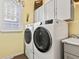 Close up of modern, front load, white washer and dryer with a yellow accent wall at 1505 Avondale Dr, Westfield, IN 46074