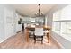 Bright dining area with wooden table, upholstered chairs, chandelier, and adjacent kitchen view at 15524 Follow Dr, Noblesville, IN 46060