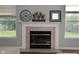 Fireplace mantel featuring a clock, decorative vases, and a picture frame, with natural light from windows at 15524 Follow Dr, Noblesville, IN 46060