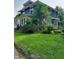 Exterior view of a green home, with lush landscaping and fencing at 1617 Blaine Ave, Terre Haute, IN 47804
