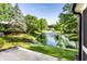 Scenic backyard view of a pond with a fountain, surrounded by lush greenery and mature trees at 1663 Cloister Dr, Indianapolis, IN 46260