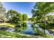 Beautiful backyard featuring a serene pond with fountain, surrounded by lush landscaping and mature trees at 1663 Cloister Dr, Indianapolis, IN 46260